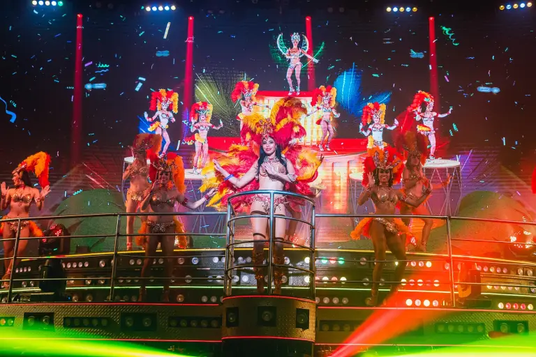 Bailarines de carnaval con plumas sobre el escenario iluminado