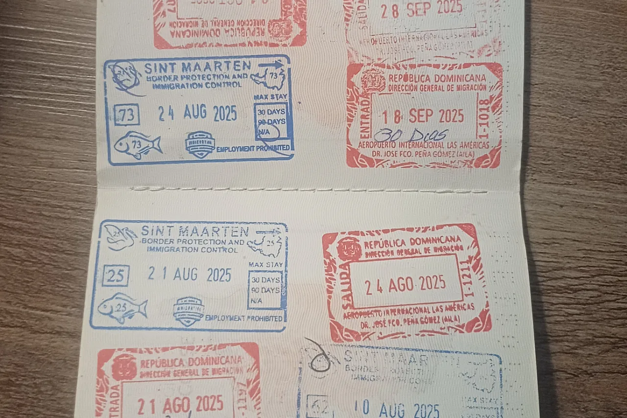 Pasaporte abierto con los sellos de entrada y salida de la República Dominicana y de Sint Maarten
